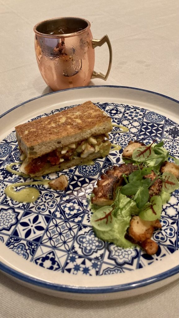 French toast di polpo, rucola, pomodoro confit, pesto di zucchine e mandorle