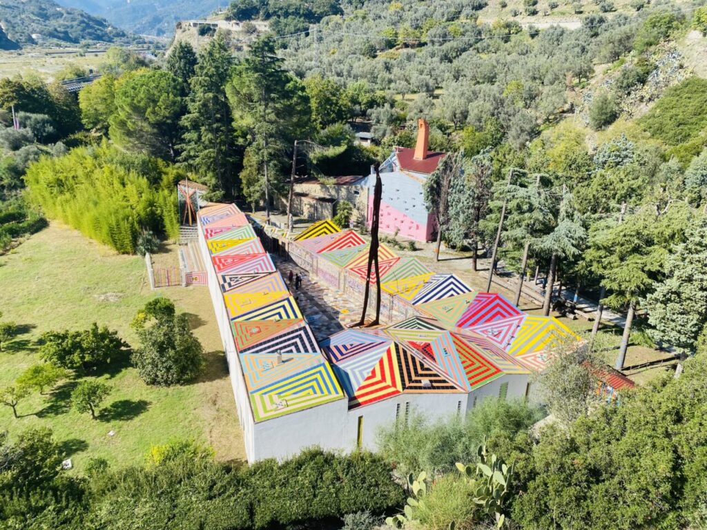 La Foresteria, che ai piedi dell’abbazia s’incontra prima della salita, con i suoi moduli policromi, richiama delle celle monastiche affacciate su di un chiostro triangolare.