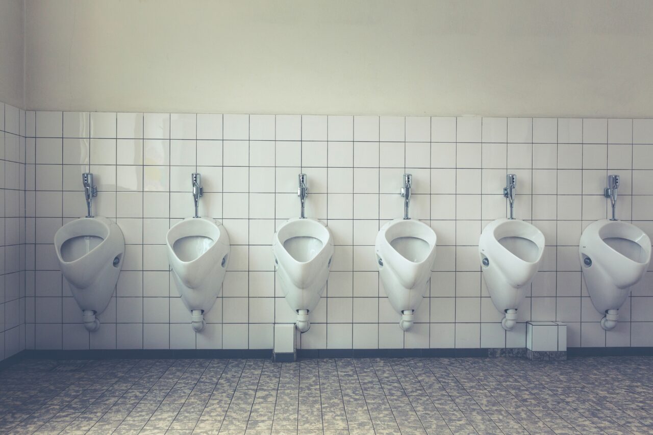 In un bagno pubblico va in scena un’umanità senza maschere