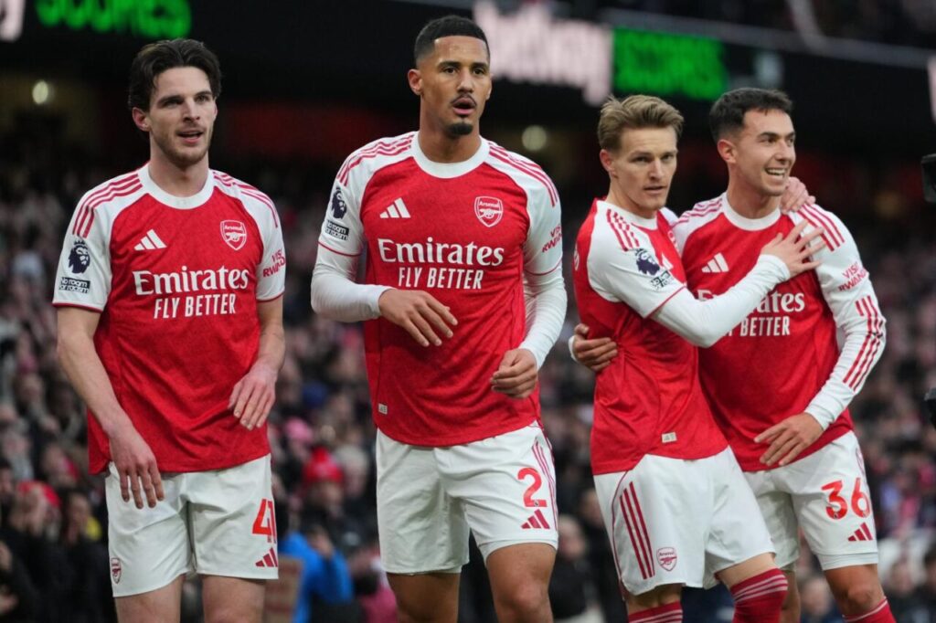 Arsenal's Declan Rice, William Saliba, scorer Martin Odegaard and Martin Zubimendi, from left, celebrate their opening goal during the English Premier League soccer match between Arsenal and Brighton and Hove Albion in London, Saturday, Dec. 27, 2025. (AP Photo/Kirsty Wigglesworth)